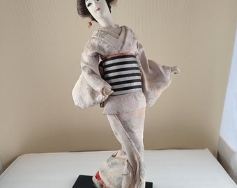 Muñeca textil antigua geisha japonesa sobre soporte de madera