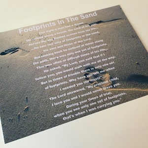 Puede incluir: Impresi&oacute;n con el poema "Footprints in the Sand" sobre un fondo de escena de playa. El texto blanco se superpone a una imagen de huellas en la arena.