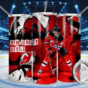 May include: A set of three stainless steel tumblers with a red, white and black design featuring the New Jersey Devils logo and a hockey player. The tumblers have a white background with a red and black design.