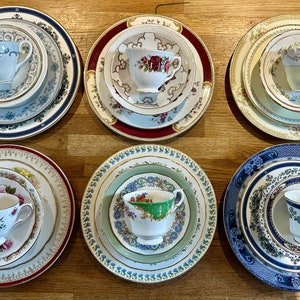 May include: Six sets of vintage teacups and saucers featuring intricate floral and geometric patterns. Each set includes a cup, saucer, and a larger plate.