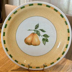 Op de afbeelding: Een geel keramiek bord met een groene rand en een ontwerp van twee peren aan een tak. Het bord heeft een gekrakelde glazuur.