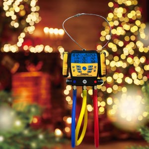 May include: A yellow and black digital HVAC manifold gauge with blue, yellow, and red hoses. The gauge has a digital display showing various readings and is suspended by a silver wire loop. The background is blurred with Christmas lights.