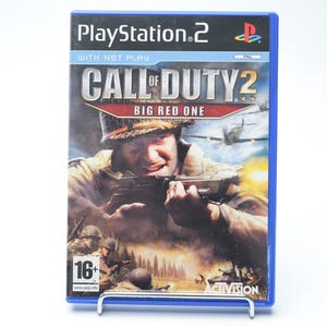 Op de afbeelding: PlayStation 2 gamehoes voor "Call of Duty 2: Big Red One". De cover toont een soldaat die een wapen richt, met een oorlogsscène op de achtergrond. De hoes heeft een blauwe rand en het Activision-logo.
