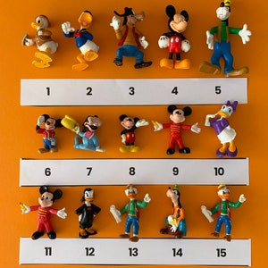 May include: A collection of 15 small plastic figurines of Disney characters, including Mickey Mouse, Minnie Mouse, Donald Duck, Goofy, and Pluto. The figurines are arranged in three rows of five, with numbers 1 through 15 printed below each figurine.