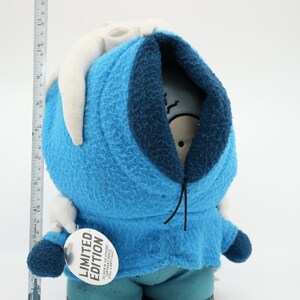 Puede incluir: Juguete de peluche azul con capucha blanca y cord&oacute;n de ajuste negro. El juguete tiene una etiqueta blanca que dice "EDICI&Oacute;N LIMITADA".