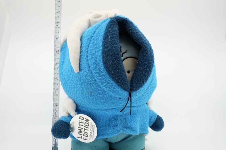 Puede incluir: Juguete de peluche azul con capucha blanca y cord&oacute;n de ajuste negro. El juguete tiene una etiqueta blanca que dice "EDICI&Oacute;N LIMITADA".