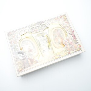 Op de afbeelding: Een doos met illustraties uit "Foxwood Tales". De doos heeft een crèmekleurige achtergrond met een decoratieve rand. De set bevat een ingelijste foto en een kleine fles. De doos staat op een witte achtergrond.