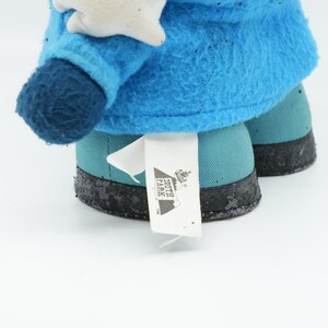 Puede incluir: Peluche azul y turquesa con una etiqueta blanca que dice "South Park" sobre un fondo blanco.