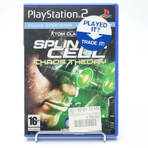 Op de afbeelding: PlayStation 2 game case voor "Splinter Cell: Chaos Theory" met een blauwe rand. De cover toont een gezicht met groene bril. Een sticker zegt "Played It? Trade It!"