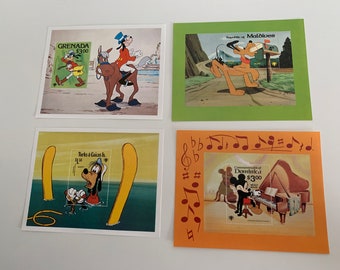 May include: Four postcards featuring different Disney characters. The top left postcard shows Goofy riding a horse with a red and white saddle. The top right postcard shows Pluto running towards a mailbox. The bottom left postcard shows Goofy in the water with a yellow surfboard. The bottom right postcard shows Mickey Mouse playing a piano with musical notes around the border.