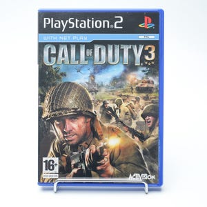 Op de afbeelding: Een PlayStation 2 game case voor "Call of Duty 3" met een blauwe rand. De cover toont soldaten in een oorlogsscène met tanks en vliegtuigen. De game is beoordeeld als 16+ en bevat het Activision logo.