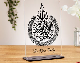 Può includere: Una placca in acrilico trasparente con un designo di calligrafia araba nera e il testo "The Khan Family" in basso.