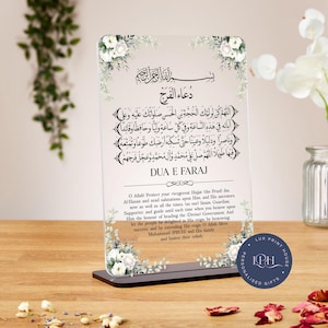 May include: A clear acrylic plaque with a black base, featuring Arabic calligraphy and English text. The design includes floral accents and the words "DUA E FARAJ." The plaque is a personalized gift.