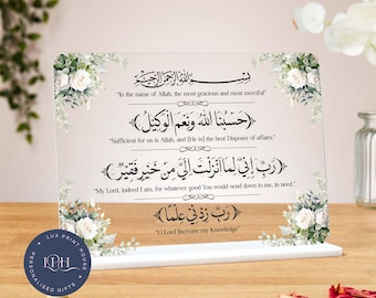 Può includere: Una placca acrilica bianca con accenti floreali e calligrafia araba. Il testo si traduce con "Nel nome di Allah, il più misericordioso, il più misericordioso."  "Allah ci basta, ed Egli è il migliore dei protettori."  "Signore mio, in verità, ho bisogno di ogni bene che Tu mi mandi."  "Oh Signore, aumenta la mia conoscenza"
