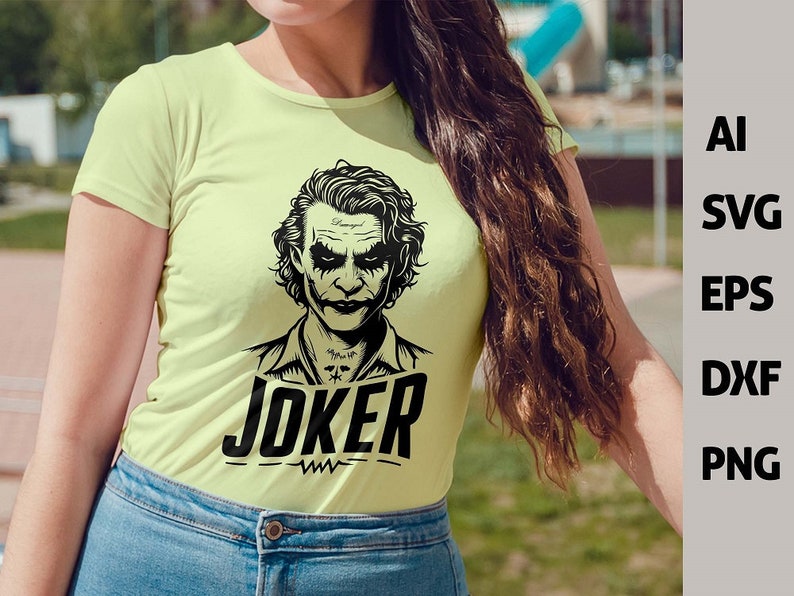 Puede incluir: Una camiseta amarilla clara con una ilustraci&oacute;n en blanco y negro del Joker de los c&oacute;mics de Batman. El texto "JOKER" est&aacute; impreso en negro debajo de la ilustraci&oacute;n.