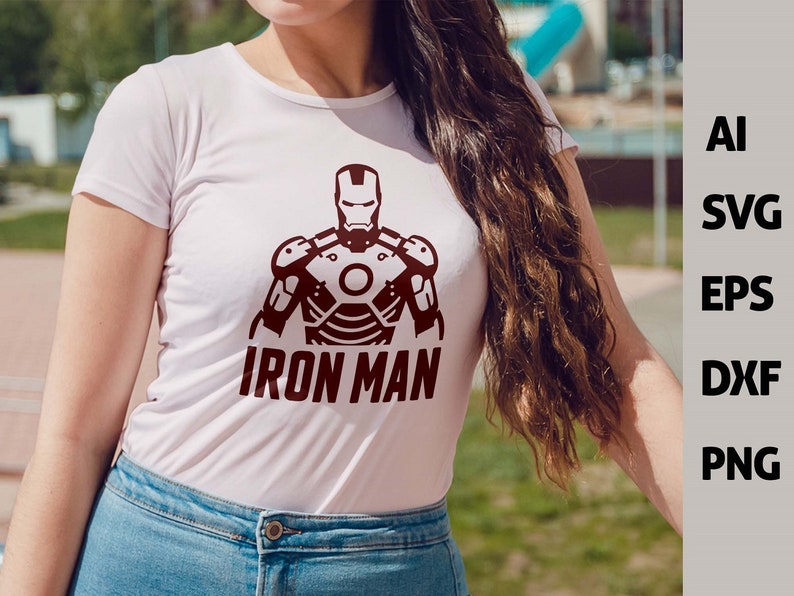 May include: White t-shirt featuring a maroon Iron Man graphic. The design includes the Iron Man helmet and armor, with the words "IRON MAN" below. The image also displays file type options: AI, SVG, EPS, DXF, and PNG.
