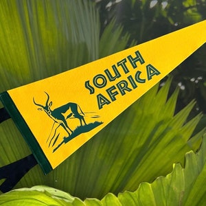 May include: A yellow pennant with green trim features a silhouette of an antelope and the text "SOUTH AFRICA" in green letters.