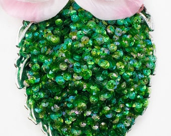 May include: A silver leaf-shaped dish filled with green iridescent sequins.