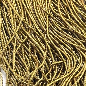 May include: Close-up of a pile of gold-colored, coiled wire. The wire is tightly wound, creating a textured surface. The image shows a dense collection of the wire, with varying shades of gold and brown.