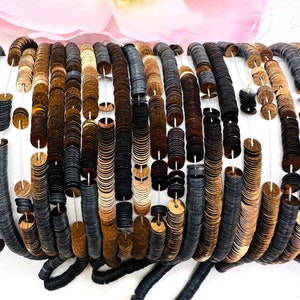 May include: A close-up of a spool of black and gold sequins. The sequins are arranged in rows and are strung on a thin thread. The sequins are round and have a slightly raised center.