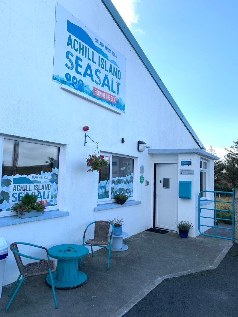 May include: A white ceramic mug with a black handle and the text "But first, coffee" in a handwritten style. The mug is designed for hot drinks and has a glossy finish.