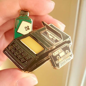 Resident Evil Emaille Pin - Tonbandgerät mit Medizin