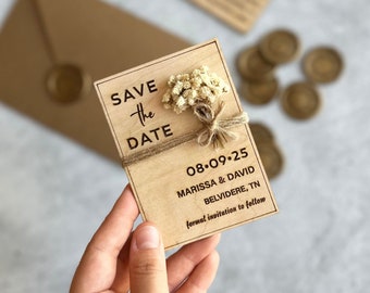 May include: A wooden save the date card with a small bouquet of dried flowers tied with twine. The card is engraved with the text "Save the Date", the date "08.09.25", the names "Marissa & David", the location "Belvidere, TN", and the phrase "formal invitation to follow".