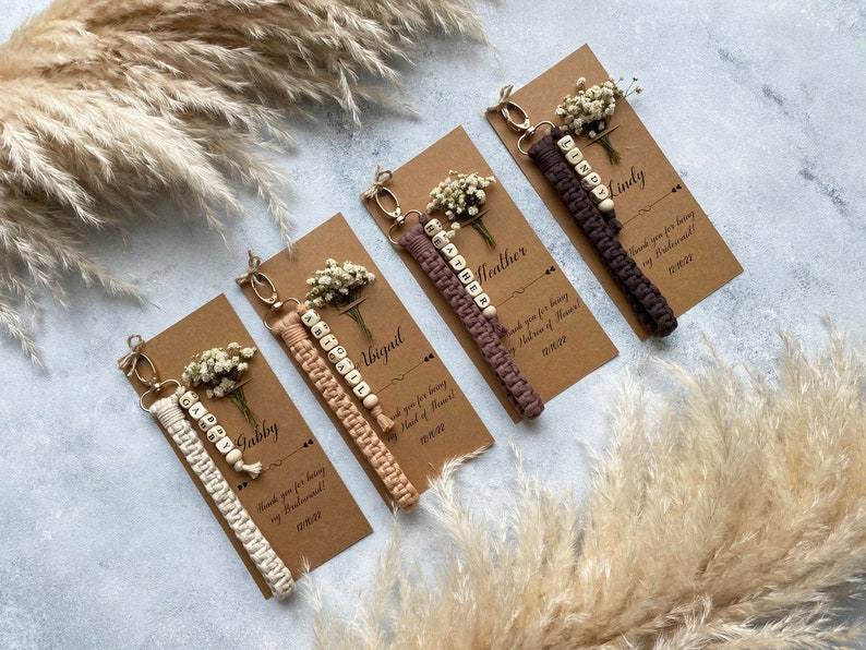 Made with 100% cotton thread, the macrame bracelet is attached to a customizable kraft card. There are flowers on the card.