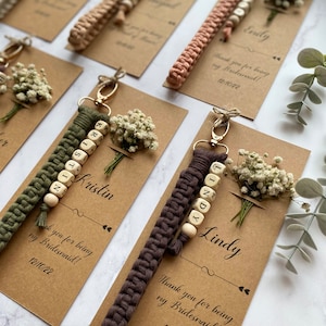Made with 100% cotton thread, the macrame bracelet is attached to a customizable kraft card. There are flowers on the card.
