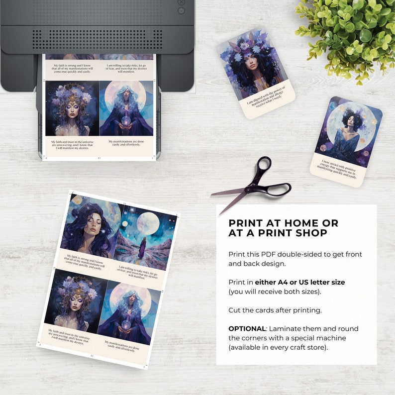 May include: A set of printable affirmation cards featuring ethereal illustrations of figures in celestial settings with text captions. The cards are displayed on a surface alongside a printer, black scissors, and a printed instruction sheet.