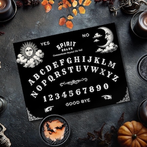 May include: A black Spirit Board with white lettering and illustrations, including a sun, moon, and numbers. The board is surrounded by candles, skulls, and autumn foliage, creating a spooky, gothic aesthetic.