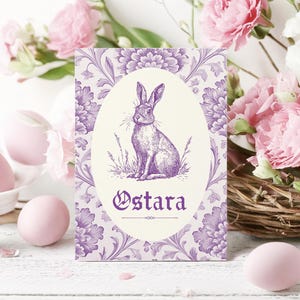 May include: Purple and white card with a floral design and a drawing of a rabbit. The card says "Ostara" in a decorative font.