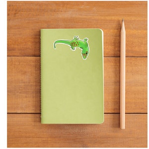 May include: A green gecko with brown spots on a light green background. The gecko is upside down with its tail curled up.