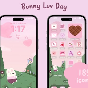 May include: A pink and green phone screen with a bunny holding a kite. The phone screen has a pink background with a white cloud and a green field. The bunny is wearing a pink shirt and has a white tail. The phone screen also has a clock that says 1:17. The phone screen has 185 icons.