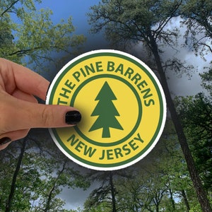 May include: A yellow and green round sticker with the text "The Pine Barrens New Jersey" and a green pine tree graphic.