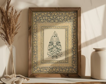 May include: A framed print with a gold and blue patterned border. The print features a green Arabic calligraphy design on a cream background.