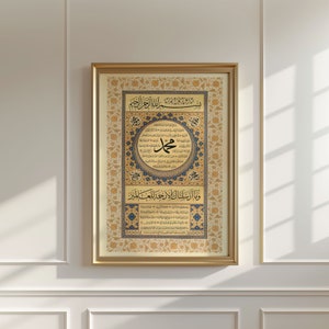 May include: A framed Islamic calligraphy artwork with gold and blue accents. The artwork features Arabic script in a circular design with a floral border. The text includes the phrase "Allah" and "Muhammad".