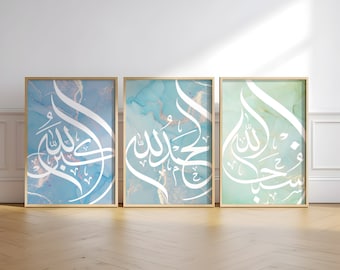 May include: Three framed prints with a white Arabic calligraphy design on a blue, green, and teal watercolor background. The Arabic text is "Allah" in a decorative font.