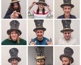 May include: Nine people wearing black top hats made of bottle caps. The hats are decorated with purple and gold accents. The people are smiling and looking at the camera.