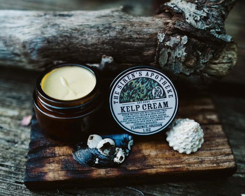Może przedstawiać: Mały słoiczek z jasnoż&oacute;łtym kremem i brązową pokrywką. Słoiczek jest oznaczony etykietą "The Siren's Apotheke Est. 2024 Kelp Cream 1 oz Florence, Oregon".