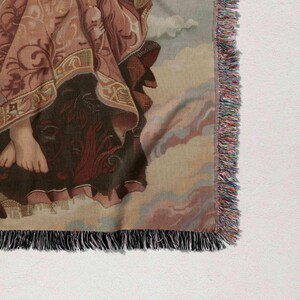 a close-up view of a decorative textile with a floral pattern and fringed edges.