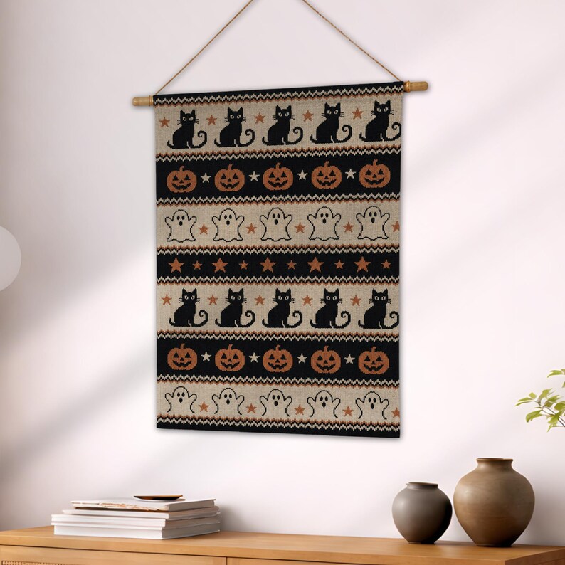 Halloween tapestry with black cats, pumpkins, ghosts, and stars on a neutral background.