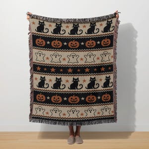 Halloween throw blanket with black cats, pumpkins, ghosts, and stars pattern.
