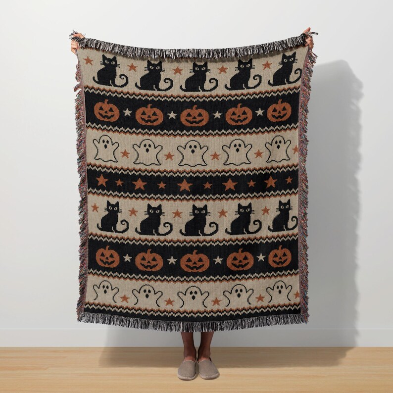 Halloween throw blanket with black cats, pumpkins, ghosts, and stars pattern.