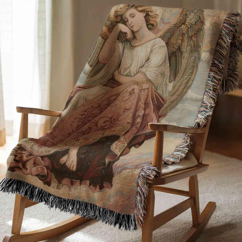 A wooden rocking chair with a blanket featuring an angel design.