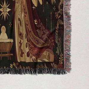 a close-up view of a decorative textile with a floral pattern and a star design. The textile has a fringe on the edges and appears to be a blanket or a throw.