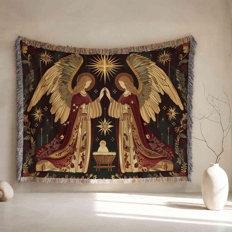 a large tapestry hanging on a wall, depicting two angels with wings and a baby in a manger. The tapestry is adorned with gold and red hues, and the background is filled with stars and a radiant sun. The tapestry is framed by a fringe border, and there are two white vases placed on either side of the tapestry.