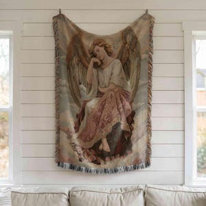a large tapestry hanging on a white wall, depicting an angel with wings and a flowing robe.