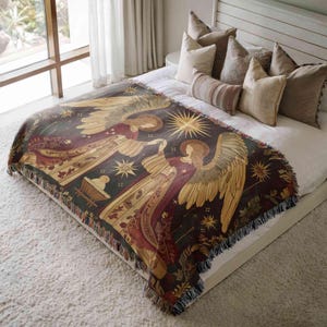 a large bed with a decorative blanket featuring a nativity scene and angels. The bed is surrounded by pillows, creating a cozy and inviting atmosphere.