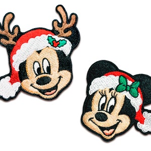 May include: Two embroidered Christmas-themed patches featuring Mickey Mouse and Minnie Mouse. Mickey Mouse is wearing a red Santa hat with antlers and a green holly sprig. Minnie Mouse is wearing a red Santa hat with a green bow. Both characters are smiling.